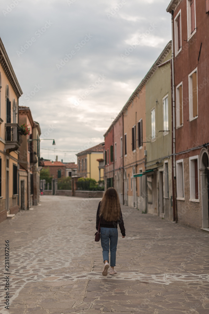 Women walking on the streets of Murano at sunset