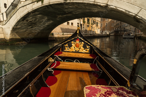 View from inside of gondola on bridge and small canal in Venice