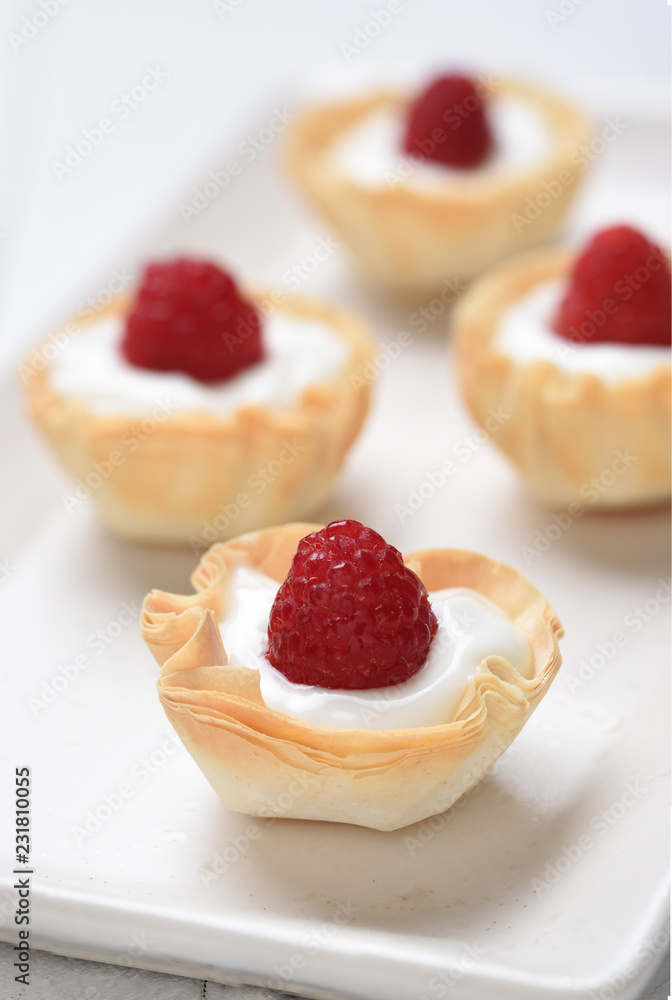 Mini Fillo Shells filled with custard topped with fresh raspberries Mini Fillo Shells filled with custard topped with fresh raspberries