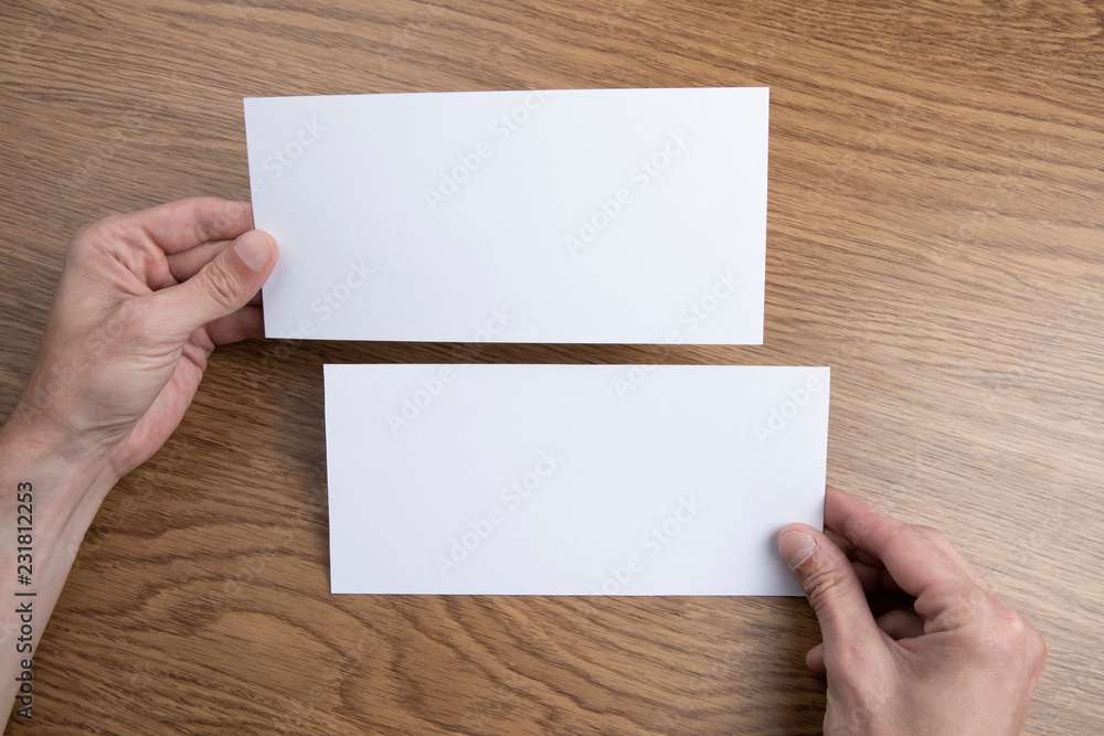 Mens hands holding white flyers Mens hands holding white flyers