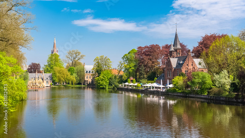 Bruges in Belgium, beautiful typical houses on the canal, and a church in background 