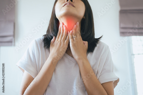 Asian woman have a sore throat,Female touching neck with hand,Healthcare Concepts