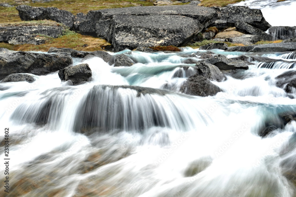 Waterfall on a mountain glacier river.