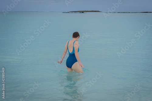 Hania  Crete - 09 27 2018  peninsula of Elafonissi. The beach paradise with emerald color water and a woman in a blue back swimsuit