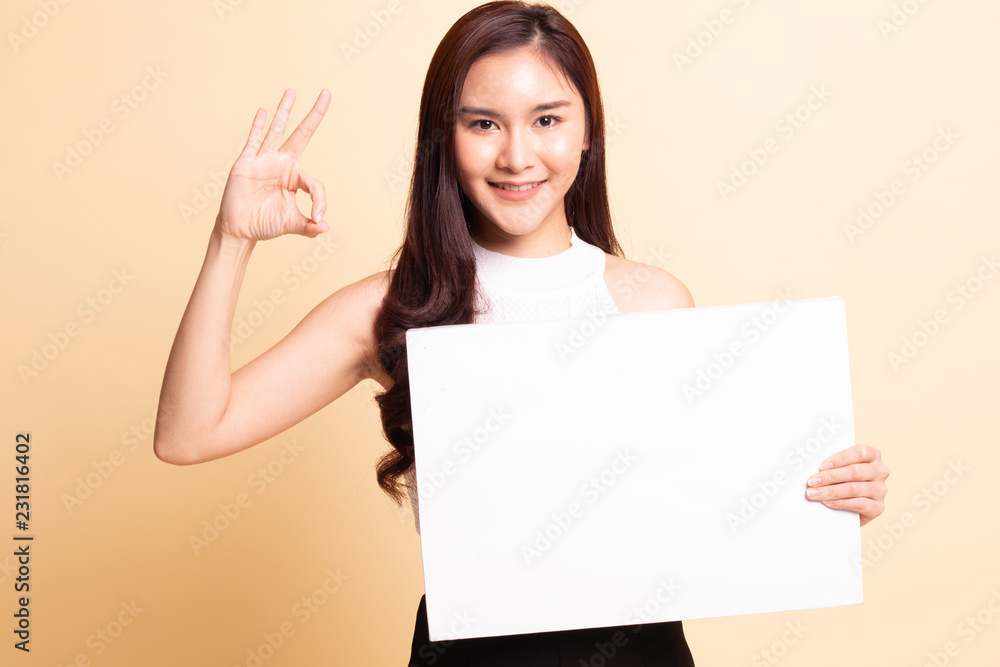 Fototapeta premium Young Asian woman show OK with white blank sign.
