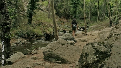 Girl hiking in nature near a waterfall photo