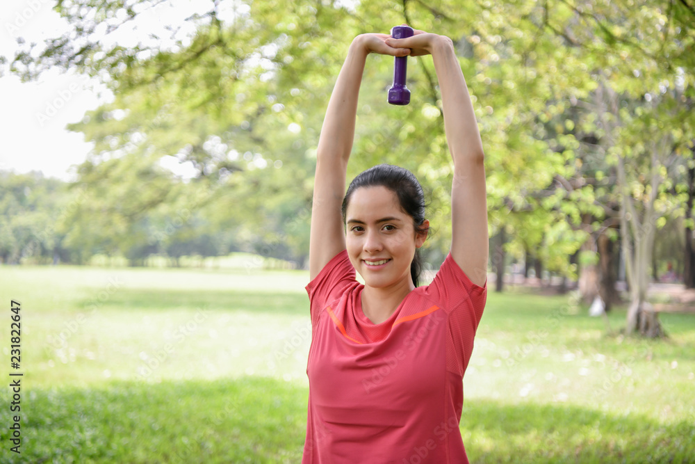 Exercise concept. Beautiful girl is stretching her muscles. Beautiful girl doing exercises with lifting dumbbell.