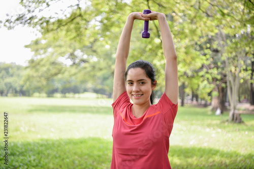 Exercise concept. Beautiful girl is stretching her muscles. Beautiful girl doing exercises with lifting dumbbell. © S photographer