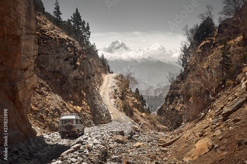 Fotobehang Off-road vehicle goes an extreme mountain path during an expedition to Himalayas