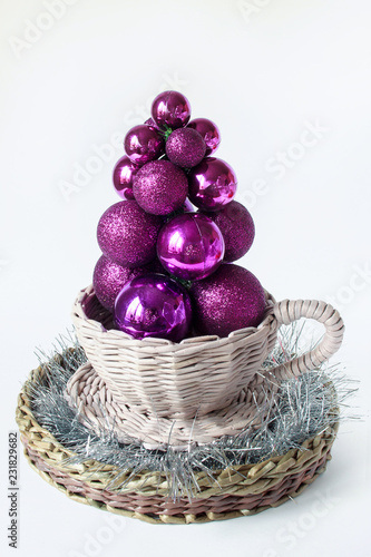 Christmas tree of balls is standing in a wicker bowl. Tradition holidays.