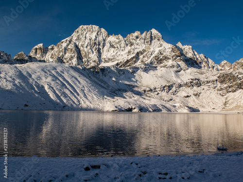 Alpine lake with fresh snow in the himalayas. gokyo Lake with a blue sky photo