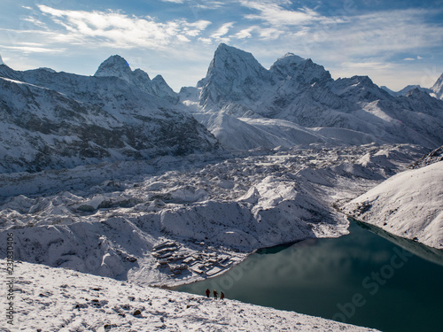 Hikers above Gokyo Lake and Gokyo with fresh snow in the Himalayas, Nepal photo