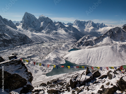 View of the Himalayas with prayer flags and Cholatse from Gokyo Ri after a snowstorm 