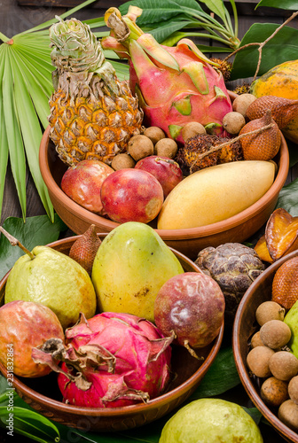 Assorted Thai tropical fruits on a dark wooden rustic background. photo