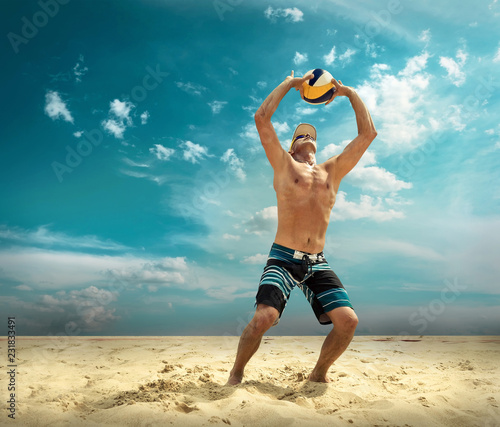 Beach volleyball player in action at sunny day under blue sky.