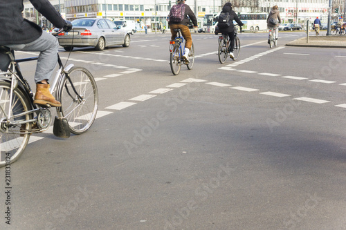 Bike riding commuters from behind in central Berlin