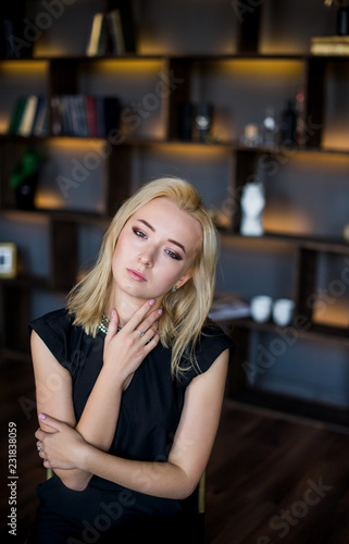 Portrait of a beautiful girl with blonde hair. A young girl in her office. Business concept
