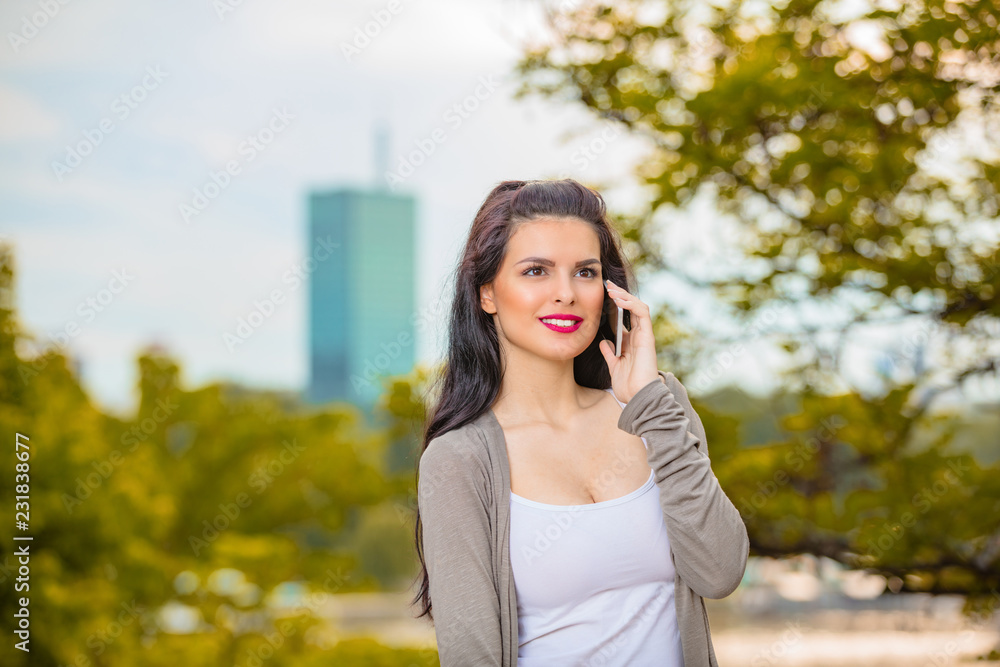 Cute young woman using cellphone in urban surroundings. Cute young woman using cellphone in urban surroundings.