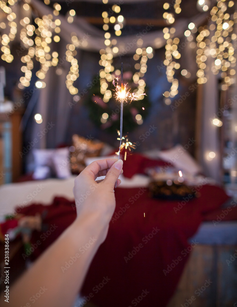 Obraz premium Night background with a star christmas sparkler. Sparkler Bokeh Colorful sparkler. Shallow focus