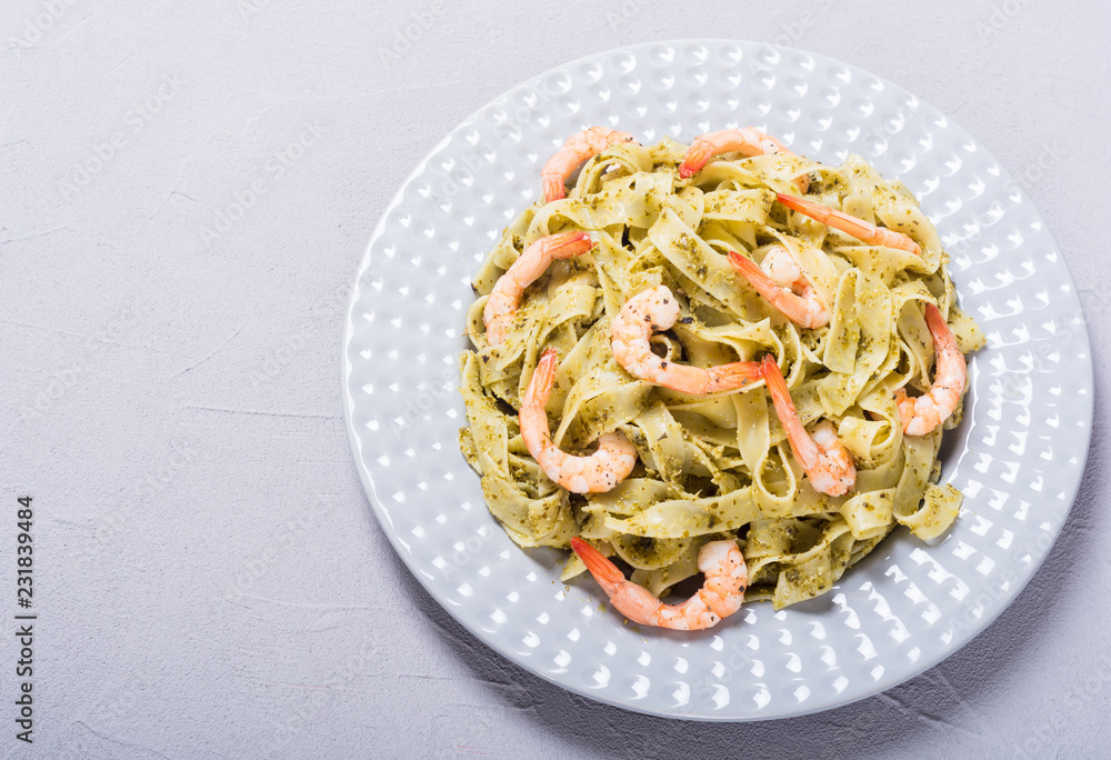 Pasta tagliatelle with sauce pesto and shrimps . Italian food background