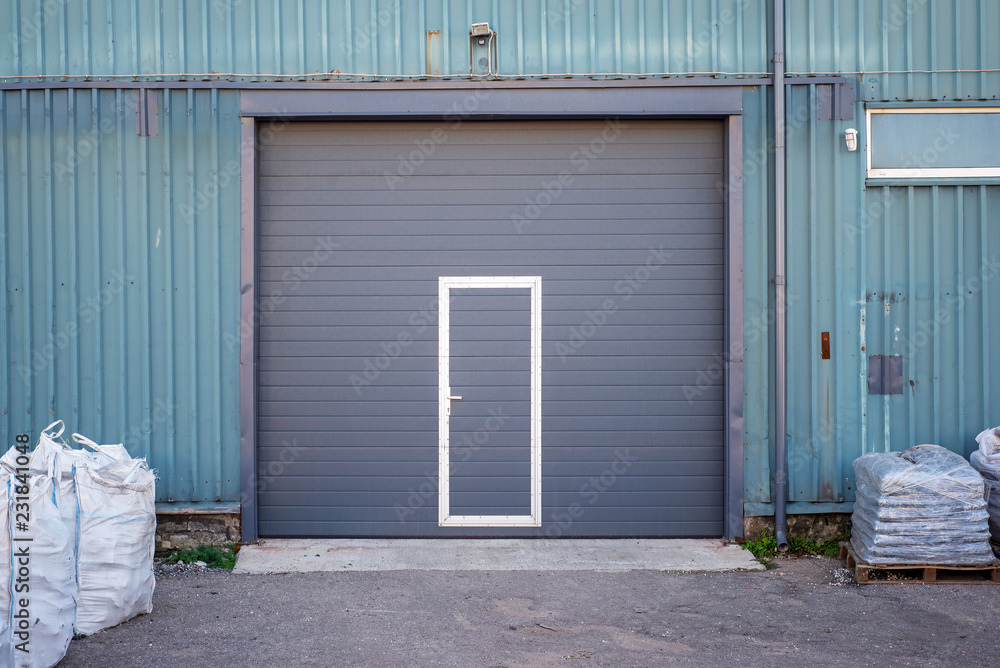 Industrial warehouse with dark grey door for vehicle