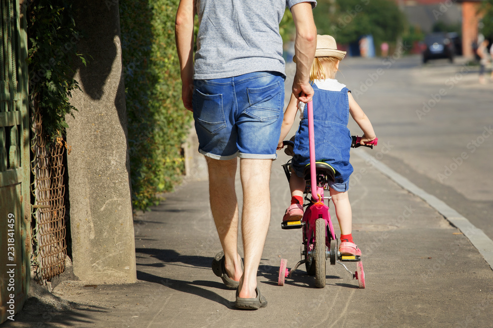 Obraz premium Father is teaching his daughter to ride a bicycle.