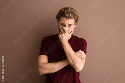Stressed young man on color background © Pixel-Shot