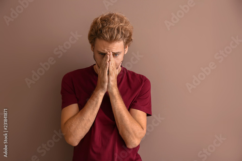 Stressed young man on color...