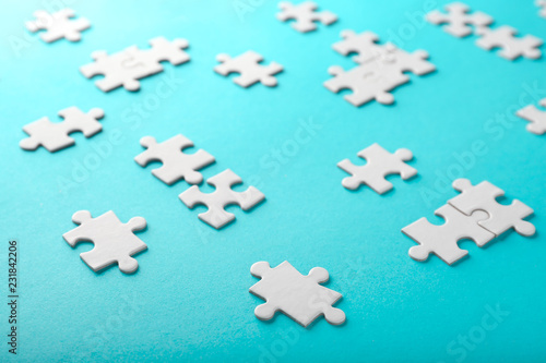 Pieces of jigsaw puzzle on color background © Pixel-Shot