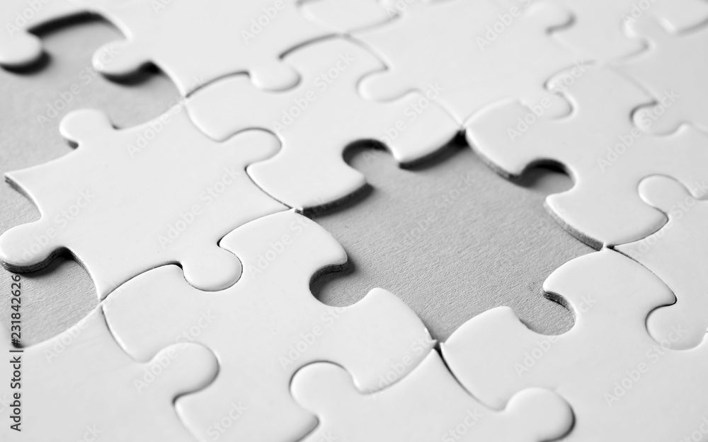 Incomplete jigsaw puzzle on light background, closeup Incomplete jigsaw puzzle on light background, closeup