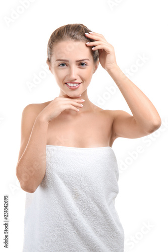 Beautiful young woman wrapped in towel on white background