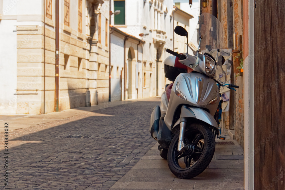 Treviso, Italy August 7, 2018: a moped is parked on a city street.