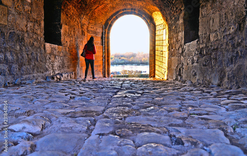 A tourist walk under one of old gates in Kalemegdan fortress and castle with Sava river and landscape in background. Belgrade Serbia