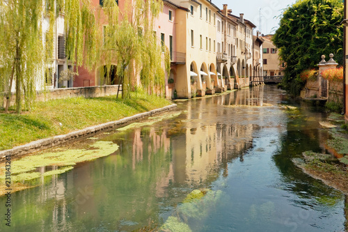 Tableau sur toile Treviso, Italy August 7, 2018: the river flows among the old buildings of the city