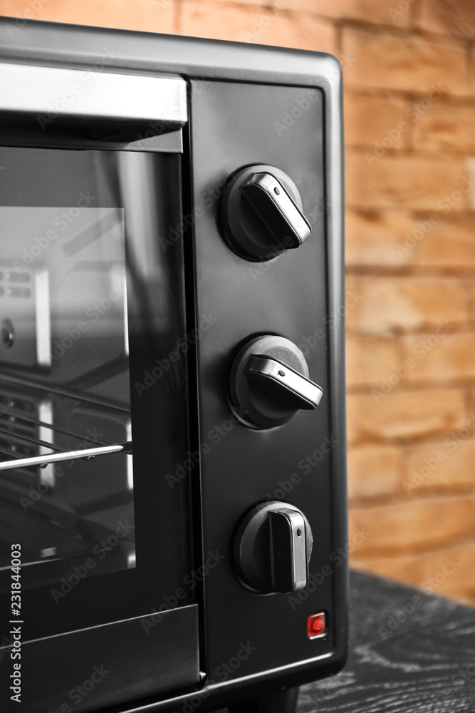 Modern electric oven on dark table, closeup Modern electric oven on dark table, closeup