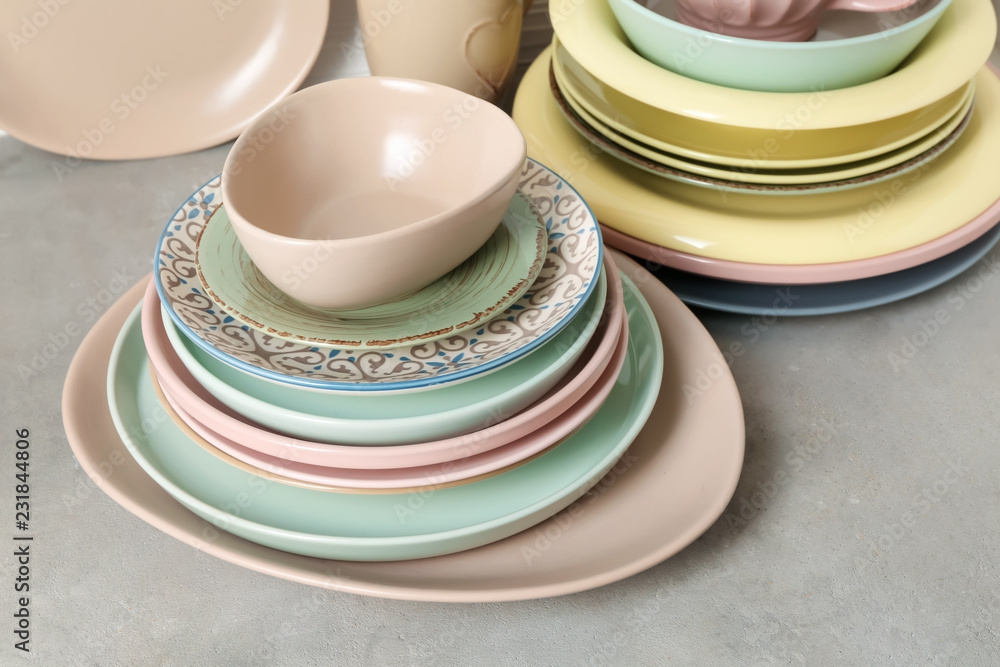 Set of clean dishware on grey table Set of clean dishware on grey table