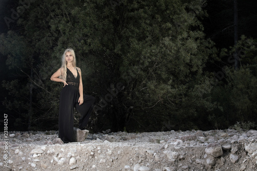 Woman in black dress standing on the rocky terrain