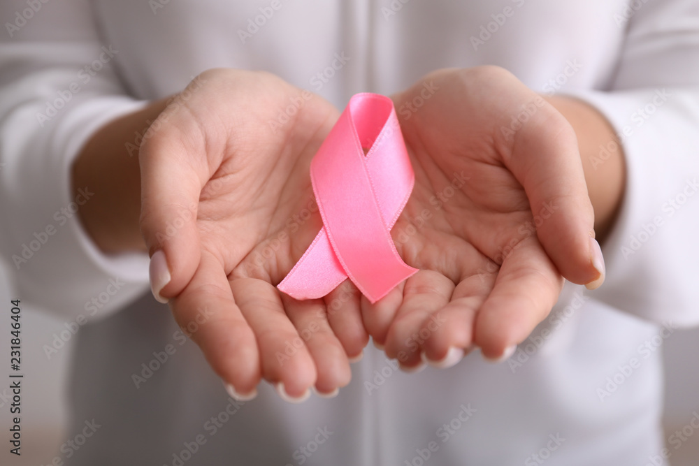 Woman holding pink ribbon, closeup. Breast cancer awareness concept Woman holding pink ribbon, closeup. Breast cancer awareness concept