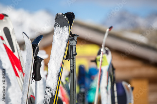 Image of multi-colored skis in snow at winter resort in afternoon.
