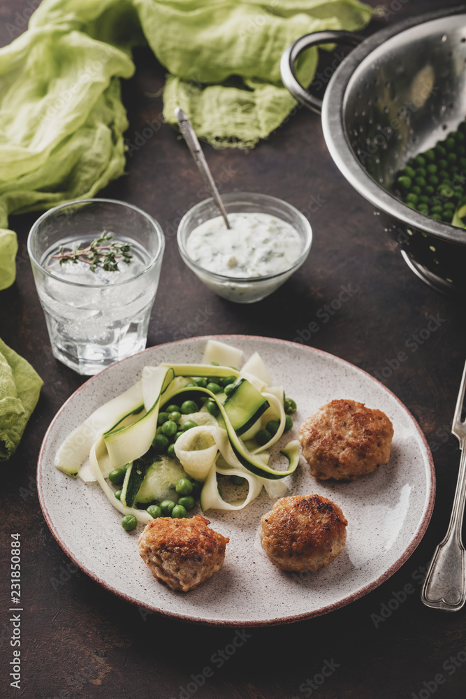 Chicken meat balls with zucchini salad and green peas, with garlic-yogurt sauce.