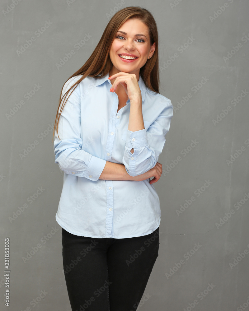 Smiling business woman wearing blue shirt standing in front of grey wall. Smiling business woman wearing blue shirt standing in front of grey wall.