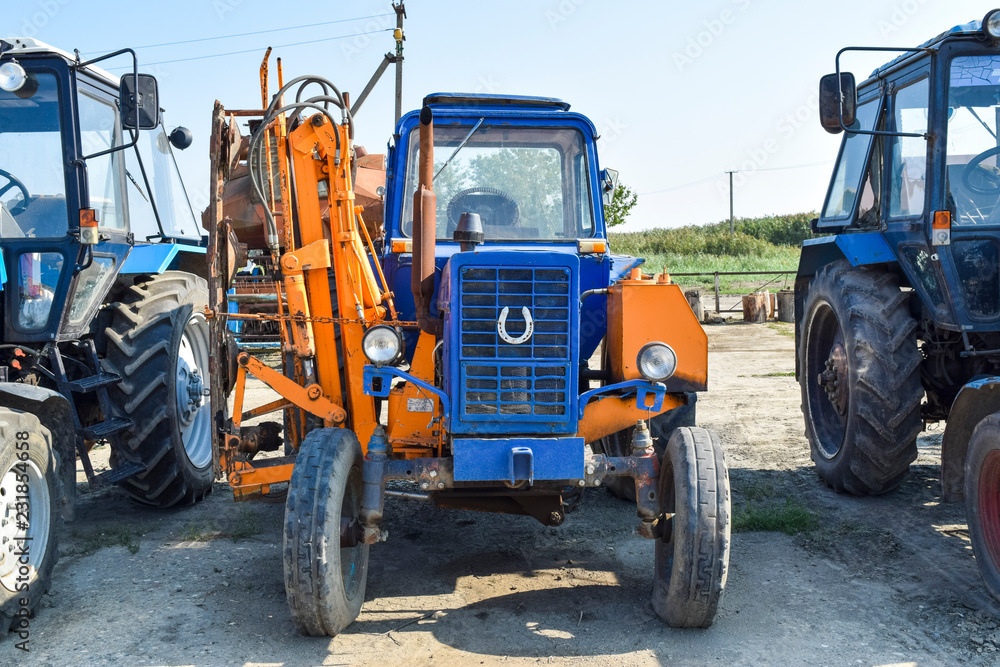 Fototapeta premium Russia, Temryuk - 15 July 2015: Tractor. Agricultural machinery tractor. Parking of tractor agricultural machinery. The picture was taken at a parking lot of tractors in a rural garage on the