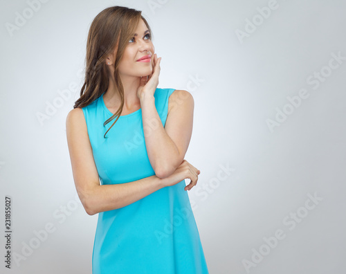 Happy smiling woman wearing blue dress looking up.