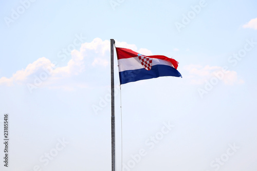 Flag of Croatia, blowing in the wind. Sky in the background, selective focus. 