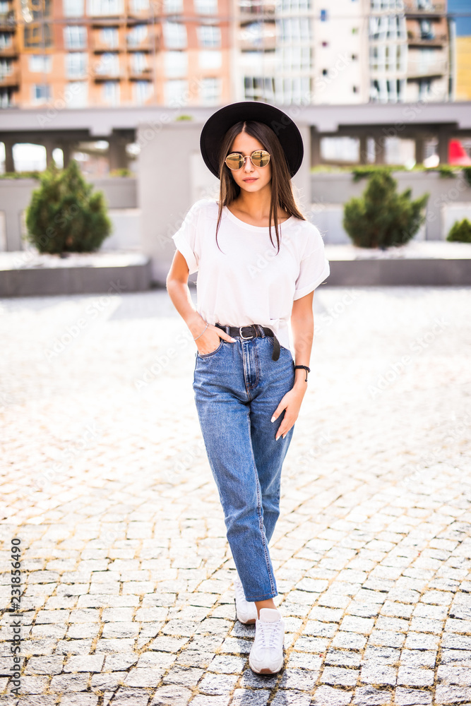 Full length of a beautiful girl in hat with sunglasses walkin on the street Full length of a beautiful girl in hat with sunglasses walkin on the street