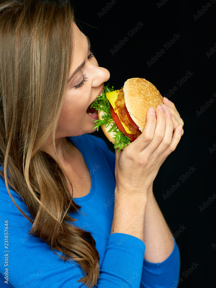 Woman eating cheeseburger, isolated portrait