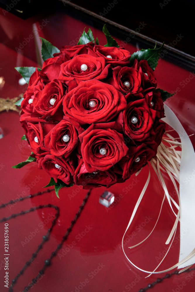 Bouquet da sposa di rose rosse con al centro di ognuna una perla bianca ...