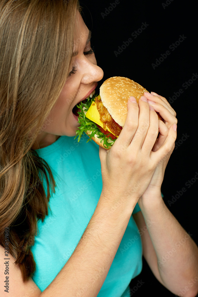 Woman eating cheeseburger, isolated portrait Woman eating cheeseburger, isolated portrait