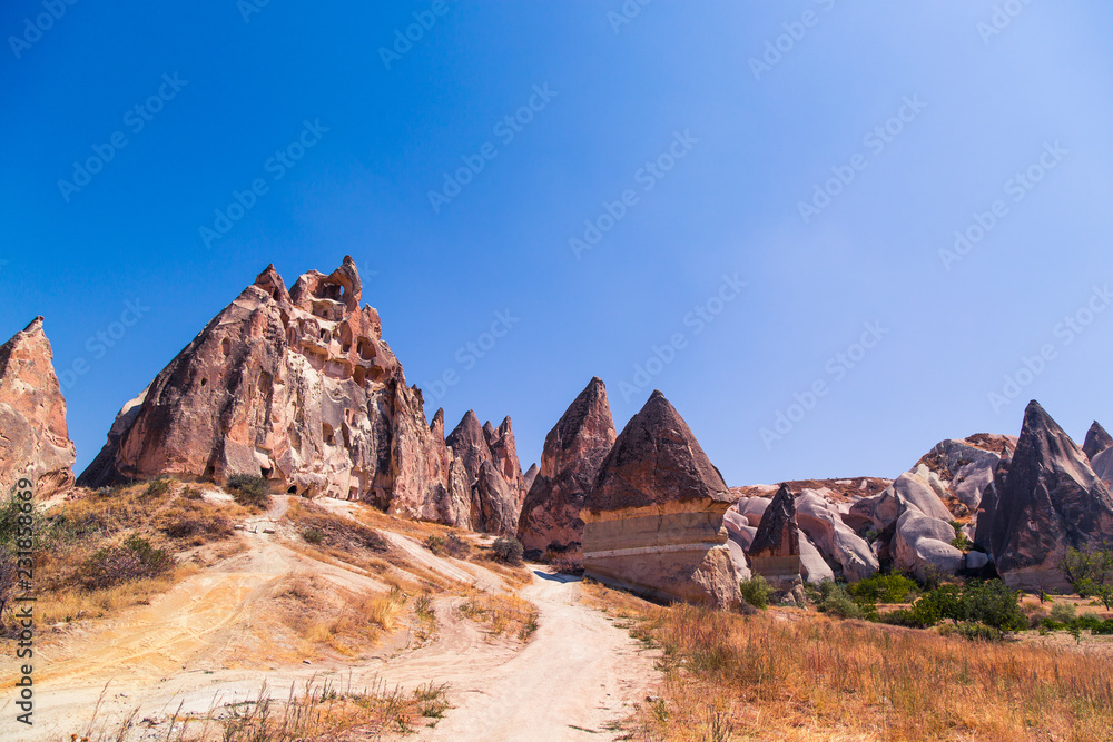 Fototapeta premium Erosion of many rocks in the desert. Dry and hot. Touristic place Cappadocia. Landscape of huge rocks and hills