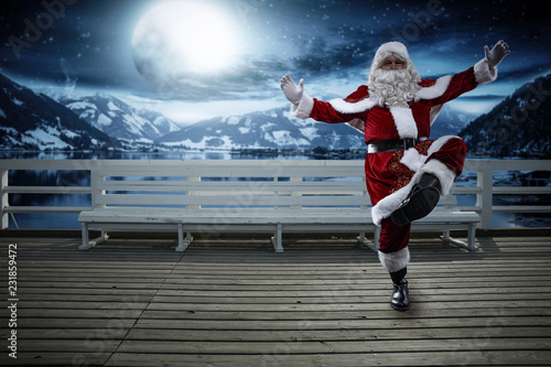 Santa Claus on wooden pier and winter night. Free space for your decoration. 